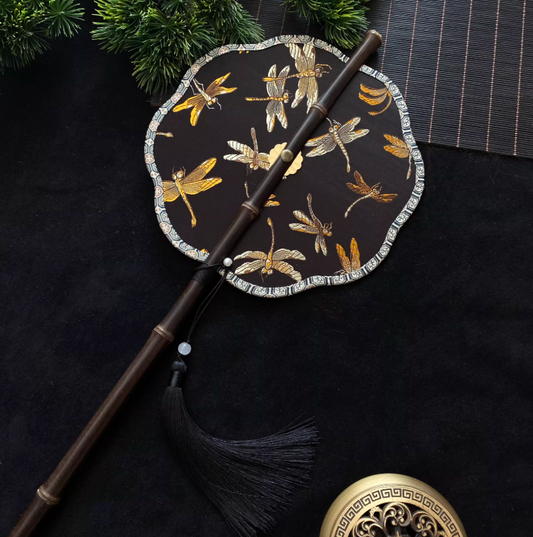 Éventail rond brodé noir et or – motif floral élégant